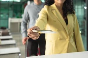 kvinna resande ger pass och biljett till personal på flygplats kolla upp i disken foto