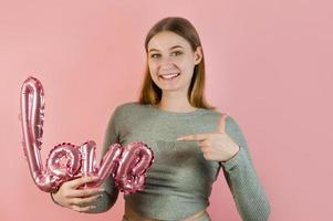 ung kvinna innehav pekande på kärlek balloon.st hjärtans dag begrepp foto