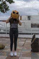 ung kvinna med en pumpa på henne huvud för halloween, dag av de död, mexico foto