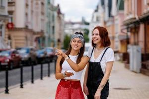 två ung kvinnor gående utomhus- har roligt foto