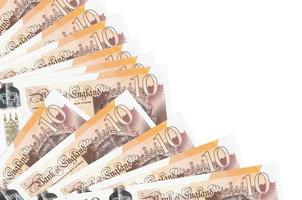 10 brittiskt pounds räkningar lögner isolerat på vit bakgrund med kopia Plats staplade i fläkt stänga upp foto