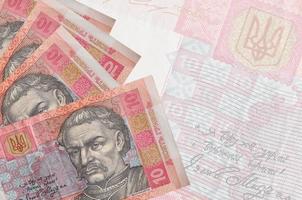 10 ukrainska hryvnias räkningar lögner i stack på bakgrund av stor halvtransparent sedel. abstrakt företag bakgrund foto