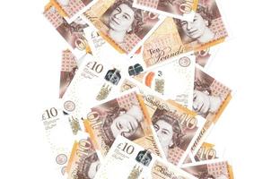 10 brittiskt pounds räkningar flygande ner isolerat på vit. många sedlar faller med vit copy på vänster och rätt sida foto