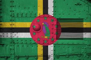 dominica flagga avbildad på sida del av militär armerad tank närbild. armén krafter konceptuell bakgrund foto