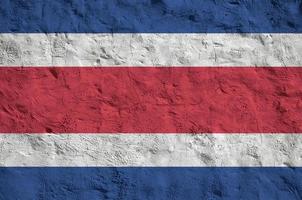 costa rica flagga avbildad i ljus måla färger på gammal lättnad putsning vägg. texturerad baner på grov bakgrund foto