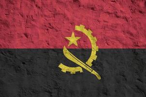 angola flagga avbildad i ljus måla färger på gammal lättnad putsning vägg. texturerad baner på grov bakgrund foto