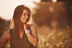 porträtt av Lycklig flicka den där stående i de fält upplyst förbi solljus foto