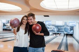 lekfullt humör. unga glada vänner har kul i bowlingklubben på sina helger foto