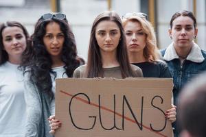 står på gatan. grupp feministiska kvinnor protesterar för sina rättigheter utomhus foto