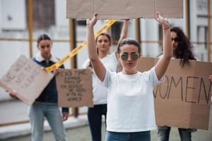 i glasögon. grupp feministiska kvinnor protesterar för sina rättigheter utomhus foto