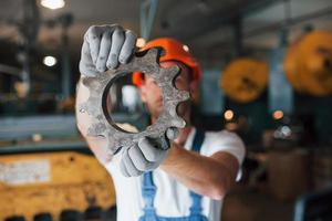 smutsig handskar. man i enhetlig Arbetar på de produktion. industriell modern teknologi foto