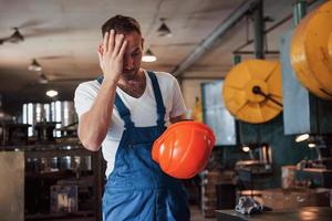 skada på arbete. känner dålig och trött. man i enhetlig. industriell modern teknologi foto