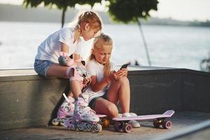 talande med varje Övrig. på de ramp för extrem sporter. två liten flickor med vält skridskor utomhus ha roligt foto