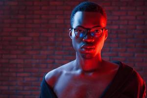 trogen neon belysning. ung afrikansk amerikan man i de studio foto