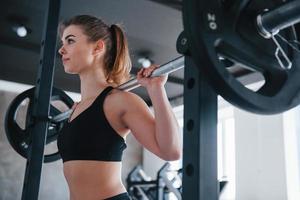 arbetssätt för de perfekt kropp. Foto av underbar blond kvinna i de Gym på henne helgen tid