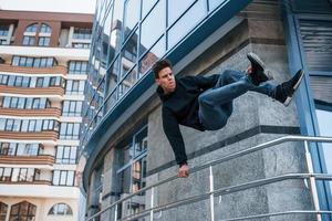 ung man håller på med parkour i de stad på dagtid. uppfattning av extrem sporter foto