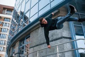 ung man håller på med parkour i de stad på dagtid. uppfattning av extrem sporter foto