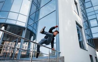 ung man håller på med parkour i de stad på dagtid. uppfattning av extrem sporter foto