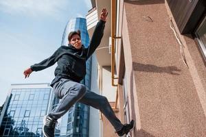 ung man håller på med parkour i de stad på dagtid. uppfattning av extrem sporter foto