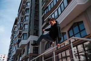 ung man håller på med parkour i de stad på dagtid. uppfattning av extrem sporter foto