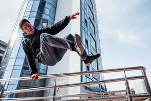 ung man håller på med parkour i de stad på dagtid. uppfattning av extrem sporter foto