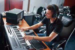 ljud ingenjör i hörlurar arbetssätt och blandning musik inomhus i de studio foto