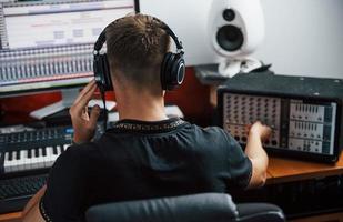 ljud ingenjör i hörlurar arbetssätt och blandning musik inomhus i de studio foto