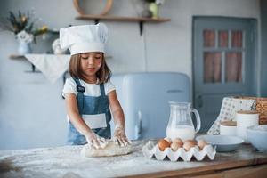 söt unge i vit kock enhetlig framställning mat på de kök foto
