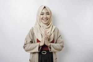 porträtt av en ung skön muslim kvinna bär en hijab gestikulerar eid mubarak hälsning foto