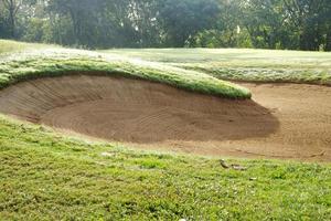 sandlåda bunkra golf kurs bakgrunder, de sandlåda på de golf kurs fairway är Begagnade som en hinder för idrottare till konkurrera foto