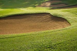 sandlåda bunkra golf kurs bakgrunder, de sandlåda på de golf kurs fairway är Begagnade som en hinder för idrottare till konkurrera foto