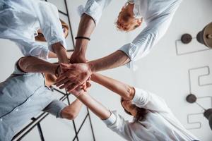 se från Nedan. framgångsrik företag människor sätta deras händer tillsammans foto