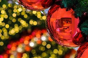 röd struntsak och Övrig prydnad hängande på jul träd med bokeh ljus bakgrund. foto