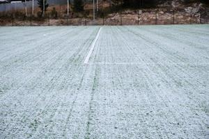 fotboll fält, gräsmatta under snö, först snö på gräs, fotboll fält markeringar foto