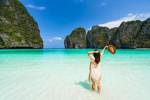 ung kvinna som resenär kopplar av och njuter av den vackra tropiska vita sandstranden vid Maya Bay i Krabi, Thailand, sommarsemester och resekoncept foto