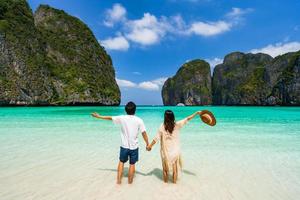 ungt parresenär som kopplar av och njuter av den vackra tropiska vita sandstranden vid Maya Bay i Krabi, Thailand, sommarsemester och resekoncept foto