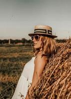 en flicka i en sugrör hatt lutade tillbaka. en solbränd flicka är vilar i de söder. sommar semester i Europa. foto