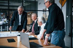 åldrig team av äldre affärsman arkitekter ha en möte i de kontor foto