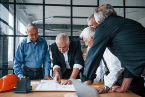 åldrig team av äldre affärsman arkitekter Arbetar med planen i de kontor foto