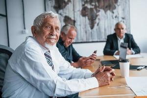 åldrig team av äldre affärsman arkitekter ha en möte i de kontor foto