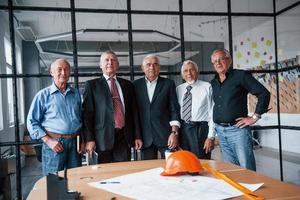 åldrig team av äldre affärsman arkitekter står i de kontor tillsammans foto