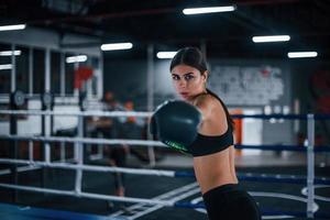 ung kvinna i sportigt ha på sig är i de boxning ringa har övning dag foto