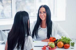 kvinna dietist ger samråd till patient inomhus i de kontor foto
