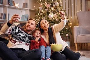 Lycklig familj inomhus i jul dekorerad rum ha roligt tillsammans och fira ny år foto