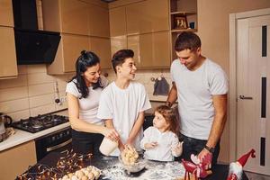 Lycklig familj ha roligt på de kök och framställning mat foto