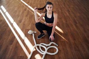 ung sportig kvinna i sportkläder trött och ha en ha sönder i de Gym foto