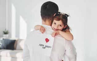Lycklig fars dag. dotter gör överraskning för pappa förbi ger vykort med hjärta foto