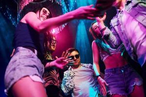se från Nedan av ung människor den där har roligt i natt klubb med färgrik laser lampor foto