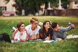 tid för en selfie. grupp av ung studenter i tillfällig kläder på grön gräs på dagtid foto