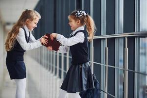 skola barn i enhetlig tillsammans i korridor. uppfattning av utbildning foto